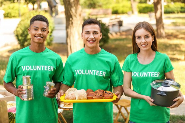 Молодые волонтеры с едой для бедных людей на открытом воздухе
 - Фото, изображение