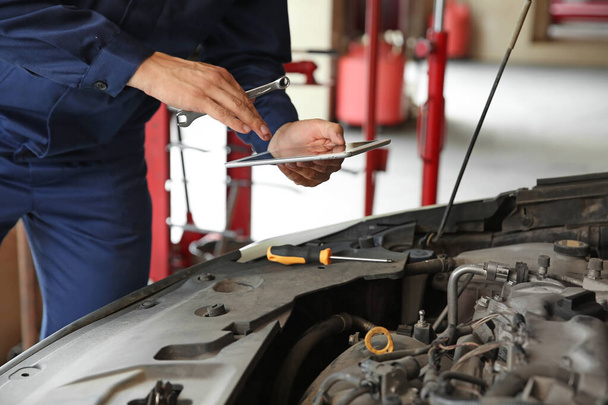 Male mechanic repairing car in service center - Photo, Image