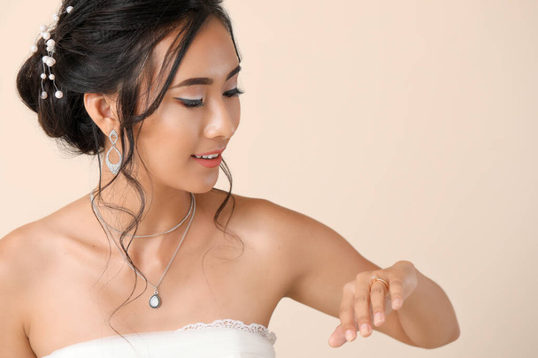 Красивая молодая азиатская невеста на светлом фоне
 - Фото, изображение