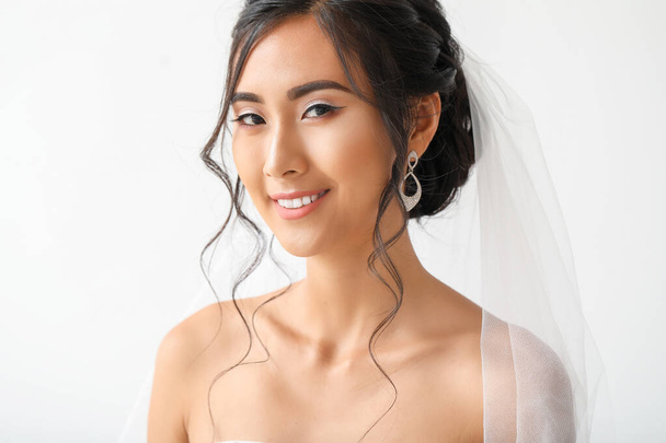 Молодая азиатская невеста на светлом фоне
 - Фото, изображение