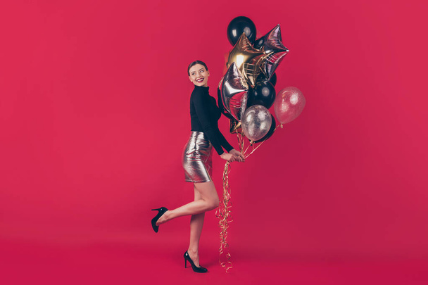 Full length body size view of nice attractive fascinating glamorous cheerful cheery girl holding in hands air balls having fun isolated over maroon burgundy marsala red pastel color background - 写真・画像