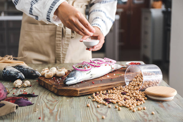 Γυναίκα προετοιμασία ψάρι σκουμπρί στην κουζίνα, κοντινό πλάνο - Φωτογραφία, εικόνα