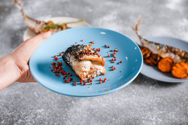 Samičí ruka s připravenou makrelou na talíři, detailní záběr - Fotografie, Obrázek
