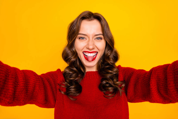 Self photo of charming cheerful attractive girlfriend showing her tongue out fooling while taking selfie isolated over yellow vivid color background - Fotoğraf, Görsel