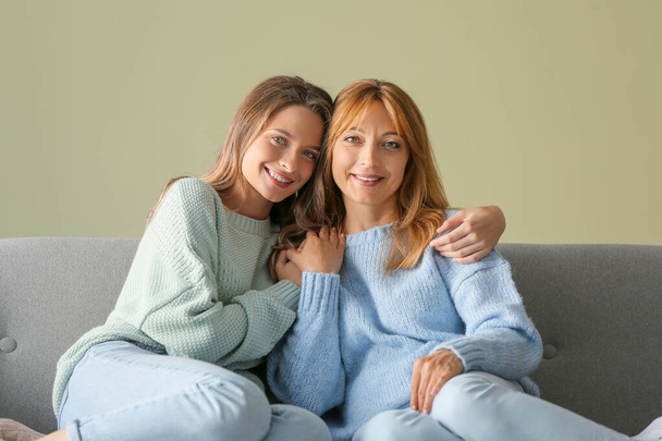 Szczęśliwa matka i córka siedzi na kanapie w domu - Zdjęcie, obraz