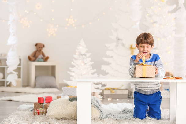 Cute little boy opening Christmas gift  at home - Foto, imagen