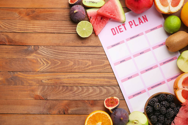 Different healthy food with diet plan on wooden table - Foto, Imagen