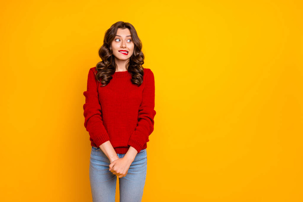 Photo of pretty curly wavy charming cute cheerful nice good girlfriend standing hesitating and shy looking away at something with hands folded isolated over yellow vivid color background - Photo, Image