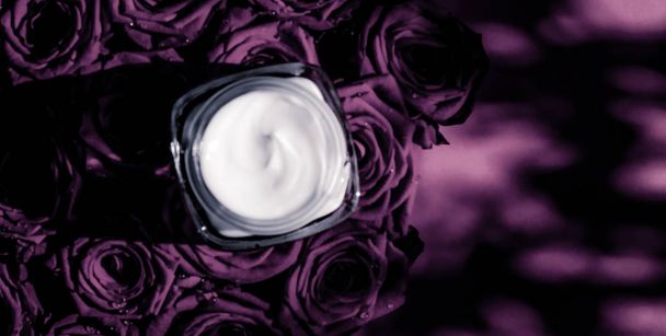 Gezicht crème huid moisturizer op paarse rozen bloemen, luxe huid - Foto, afbeelding