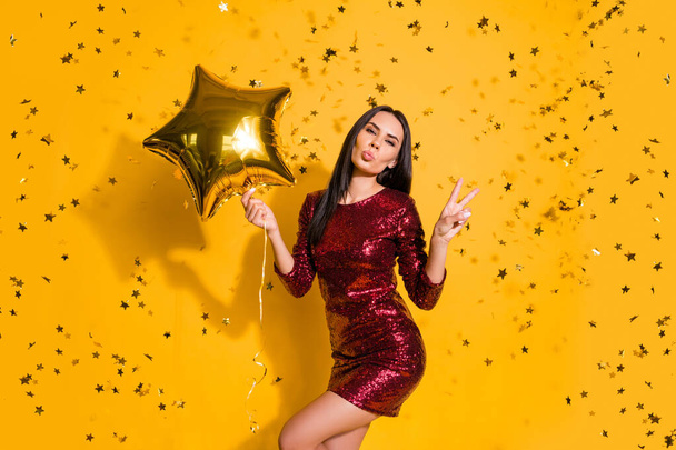 Portrait of nice attractive lovely gorgeous fascinating slim fit slender graceful cheerful girl holding in hands air ball showing v-sign isolated on bright vivid shine vibrant yellow color background - Фото, изображение