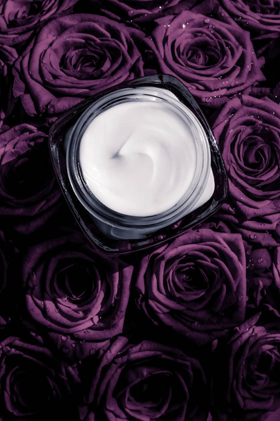 Ενυδατική κρέμα προσώπου σε μωβ τριαντάφυλλα λουλούδια, πολυτέλεια δέρμα - Φωτογραφία, εικόνα