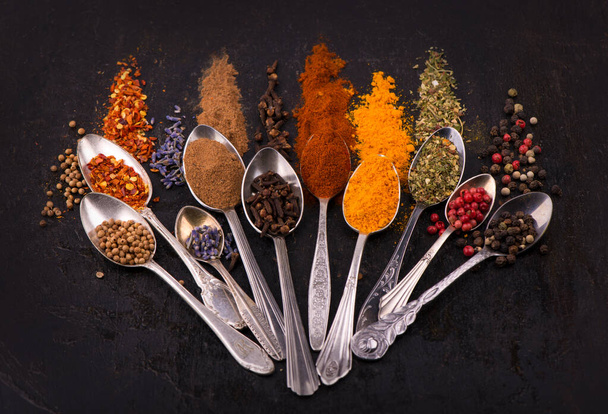 Spices and condiments for cooking on a black background - Фото, зображення