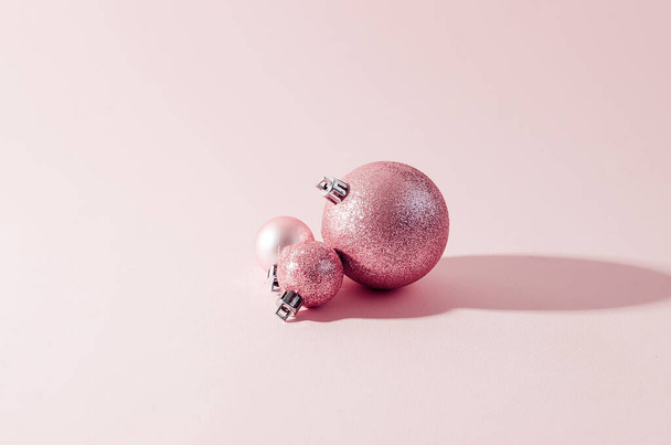 pink christmas balls on pink paper background - Foto, afbeelding
