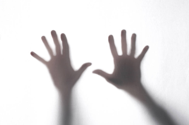 schaduw of silhouet van de handen van twee mannen die een witte stof van achteren aanraken in transparantie met kopieerruimte voor uw tekst - Foto, afbeelding