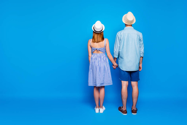 Rear back behind full length body size view of his he her she two nice attractive people holding hands spending vacation summertime day isolated on bright vivid shine vibrant blue color background - Foto, Imagem
