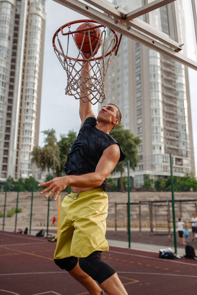 Basketball ball hits the basket outdoor, nobody. Streetball sport, game concept - Фото, изображение
