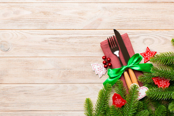 Κάτοψη των εορταστικών μαχαιροπήρουνα για το νέο έτος ξύλινο φόντο. Χριστουγεννιάτικες διακοσμήσεις με κενό χώρο για το σχεδιασμό σας. Σχέδιο εορταστικού δείπνου - Φωτογραφία, εικόνα