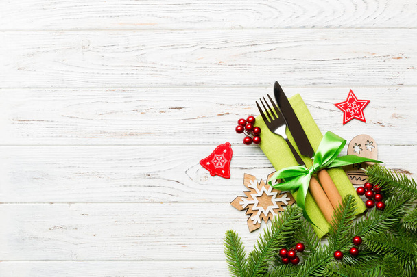 Верхний вид рождественских украшений на деревянном фоне. Вилка и нож на салфетке связаны лентой и пустое место для вашего дизайна. Концепция нового года - Фото, изображение