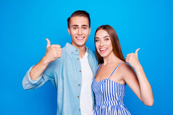 Close-up portrait of his he her she two nice attractive lovely content cheerful cheery glad people embracing showing thumbup isolated over bright vivid shine vibrant blue color background - Photo, image