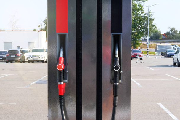燃料ステーションの黒と赤の燃料ピストル。ガソリンとガソリン製品のコンセプト。ガソリンポンプでガソリンを汲み上げる. - 写真・画像