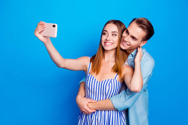 Portrait of his he her she two nice attractive charming cute tender cheerful cheery glad people embracing taking selfie memories isolated on bright vivid shine vibrant blue color background - Foto, Imagen