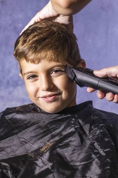 Mały chłopiec idzie do fryzjera z maszyną do cięcia - Zdjęcie, obraz
