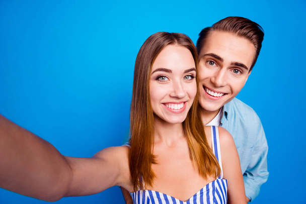 Self-portrait of her she his he two nice attractive lovely sweet tender adorable cheerful cheery partners hugging traveling isolated over bright vivid shine vibrant blue color background - Foto, Imagem