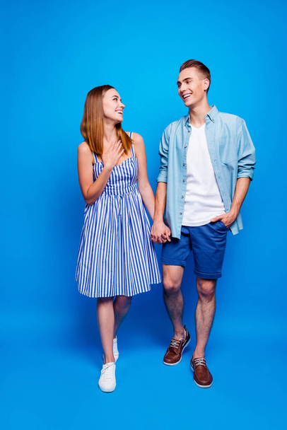 Vertical full length body size view of his he her she two nice attractive charming delighted cheerful cheery people walking isolated over bright vivid shine vibrant blue turquoise color background - Photo, image