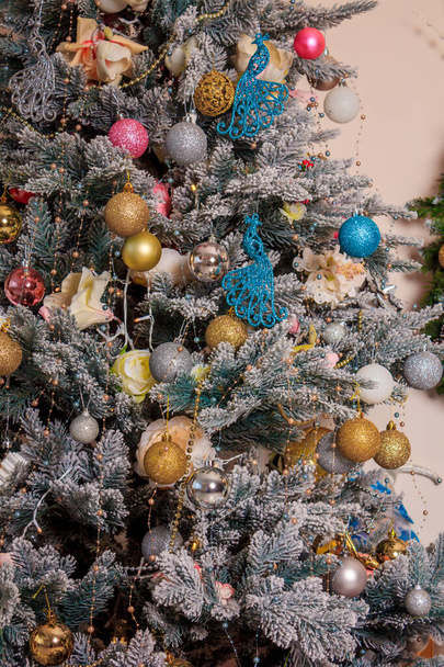 Τα πρωτοχρονιάτικα παιχνίδια κρέμονται σε ένα χριστουγεννιάτικο δέντρο. Χριστουγεννιάτικη διακόσμηση. Πρωτοχρονιά και Χριστούγεννα. - Φωτογραφία, εικόνα