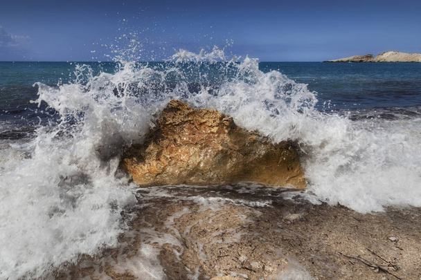 Хвиля, підхоплена, розбивається об валун на пляжі Петані на грецькому острові Кефалонія., - Фото, зображення