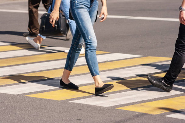 benen van jonge voetgangers die op de oversteekplaats lopen - Foto, afbeelding
