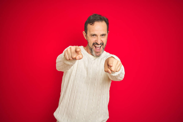 Handsome middle age senior man with grey hair over isolated red background pointing to you and the camera with fingers, smiling positive and cheerful - Photo, Image