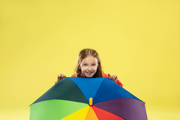 Een volledige lengte portret van een helder modieus meisje in een regenjas - Foto, afbeelding