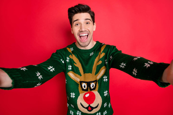 Close up photo of funny funky crazy man make selfie enjoy newyear christmas celebration wear deer reindeer trendy sweater isolated over red color background - Photo, image