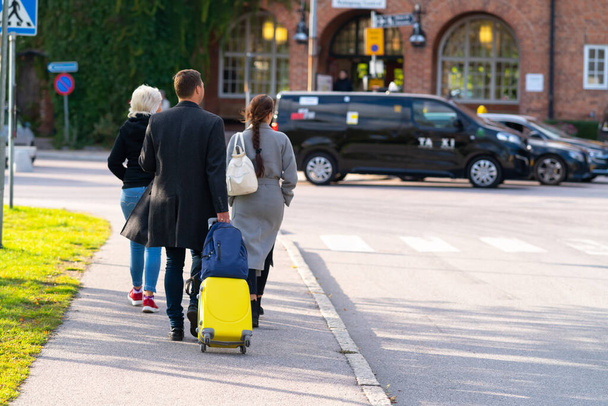 Family walking in town with luggage - Foto, Bild