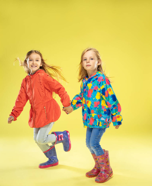 A full length portrait of a bright fashionable girls in a raincoat - Foto, Imagen