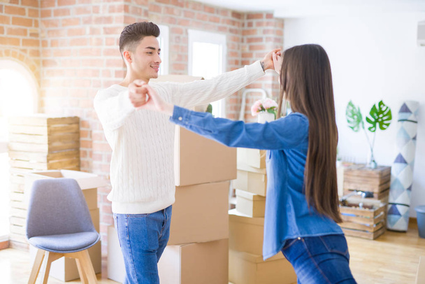 Young asian couple dancing and smiling celebrating moving to a new home - Foto, immagini