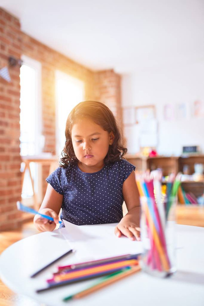 Hermosa niña dibujo lindo dibujo utilizando lápices de colores en el jardín de infantes
 - Foto, imagen