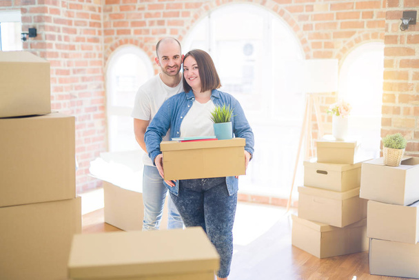 Giovane coppia che si trasferisce in una nuova casa, sorridente felice contenente scatole di cartone
 - Foto, immagini