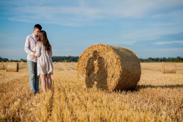 Happy young couple on straw, romantic people concept, beautiful landscape, summer season - Photo, Image