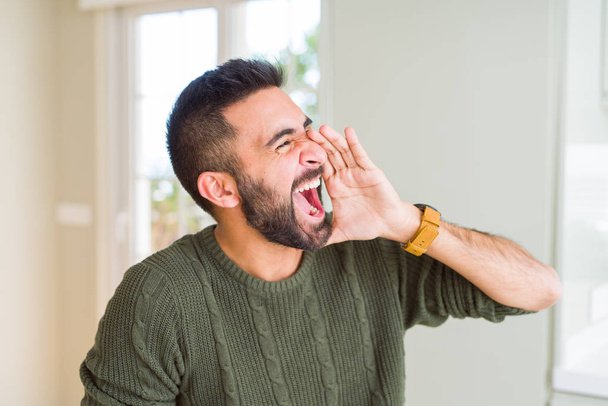 Mies huutaa raivolla peittäen suun käsillään, huutaen turhautuneena ja hulluna
 - Valokuva, kuva