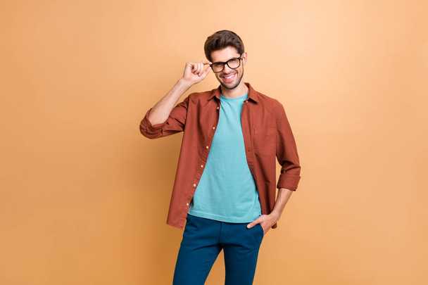 Portrait of his he nice attractive fashionable cheerful cheery brunet guy touching specs posing new cool modern look isolated over beige color pastel background - Foto, Imagem