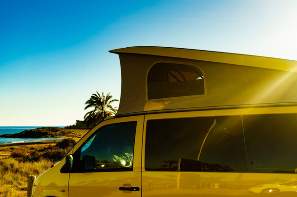 Кемпер-фургон с палаткой на крыше на пляже
 - Фото, изображение