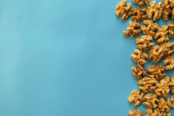 Орехи на синем фоне с копировальным пространством. Орехи плоские лежал, вид сверху
. - Фото, изображение