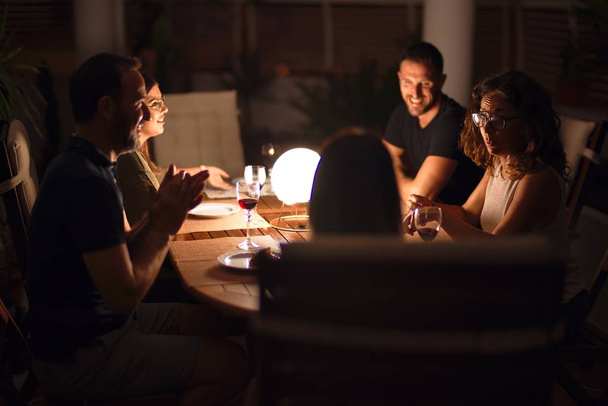Beautiful family on dinner talking and smiling at terrace - Valokuva, kuva