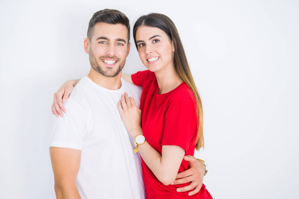 Young beautiful couple in love hugging over white isolated background - Foto, imagen