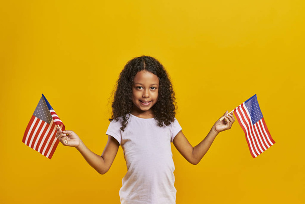 Afrikkalainen tyttö heiluttaa Amerikan liput
  - Valokuva, kuva