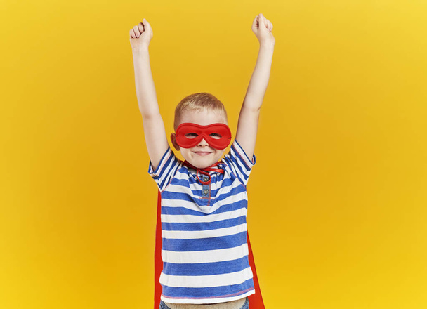 Criança como super-herói com as mãos levantadas
 - Foto, Imagem
