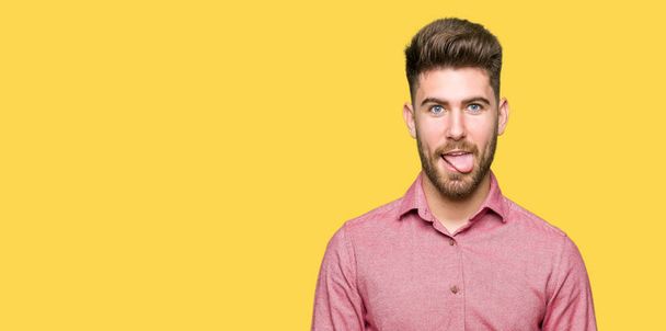 Jonge knappe zakelijke casual man steken tong uit gelukkig met grappige uitdrukking. Emotion concept. - Foto, afbeelding