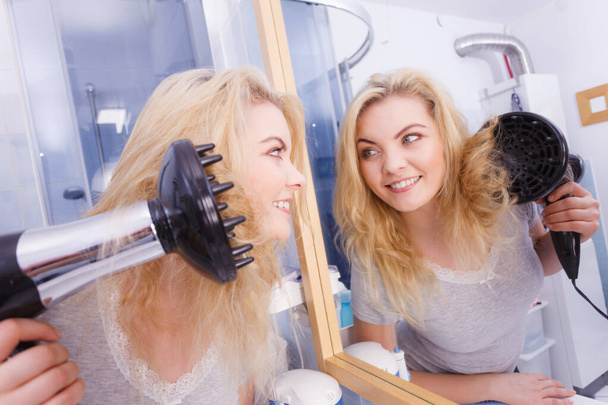 Woman doing curls with hairdryer diffuser - Foto, afbeelding